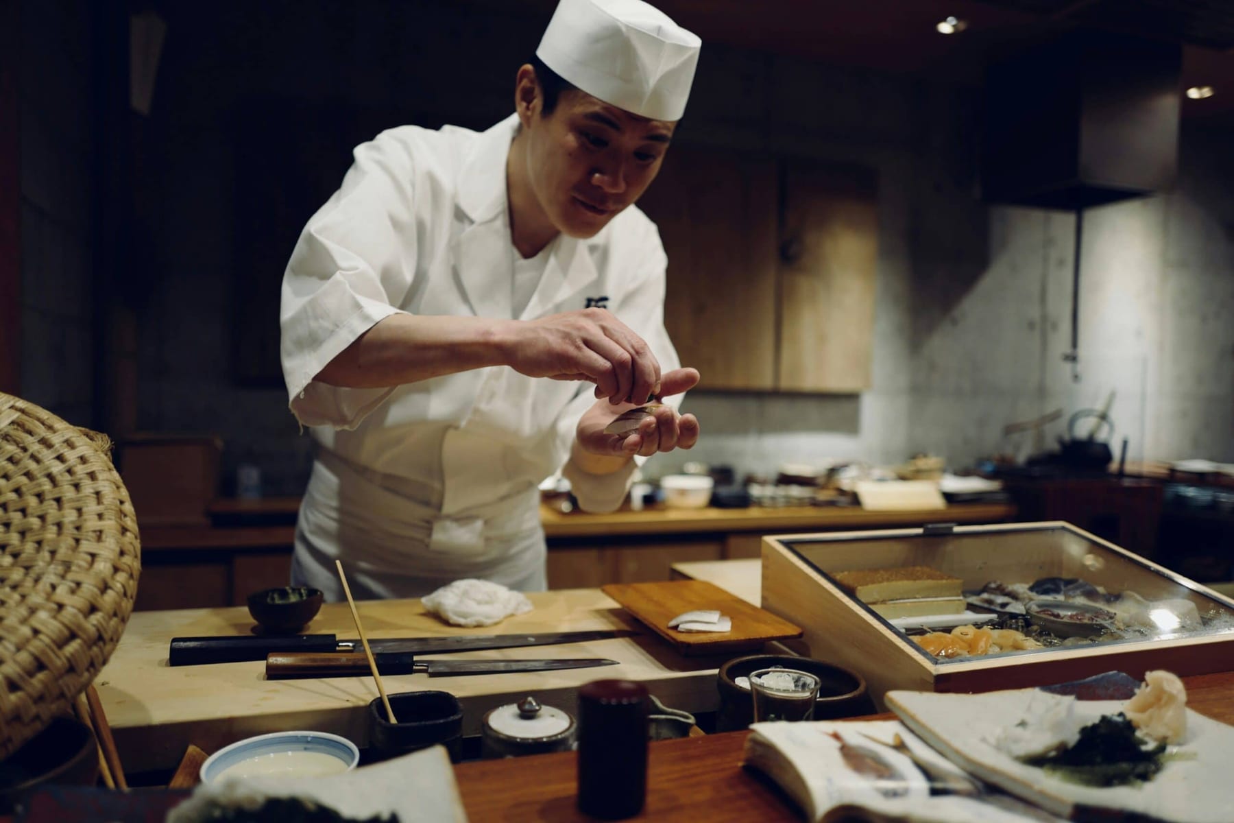 Edomae sushi master at work behind a hinoki counter in Tokyo