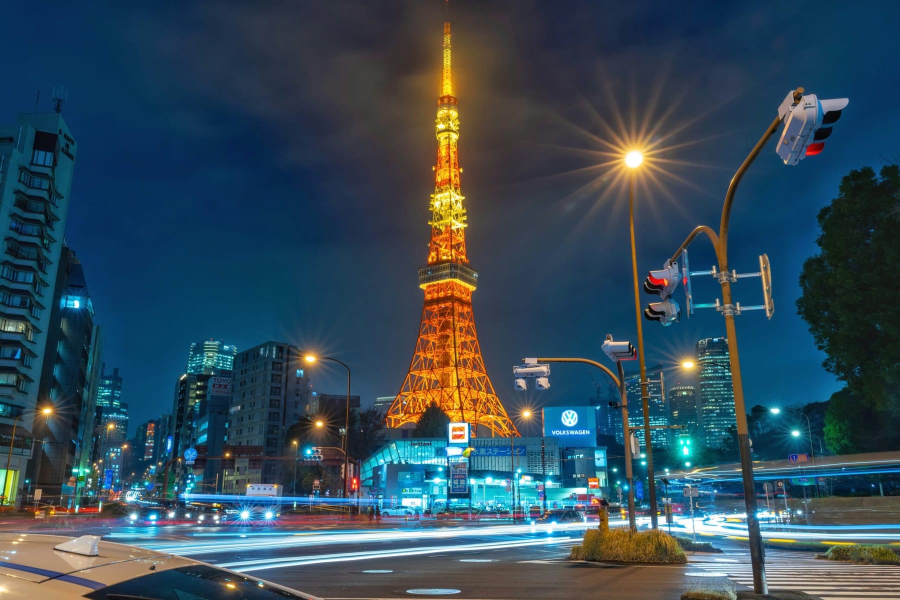 Tokyo Tower illuminated at night, rising above the city's low-rise neighbourhoods
