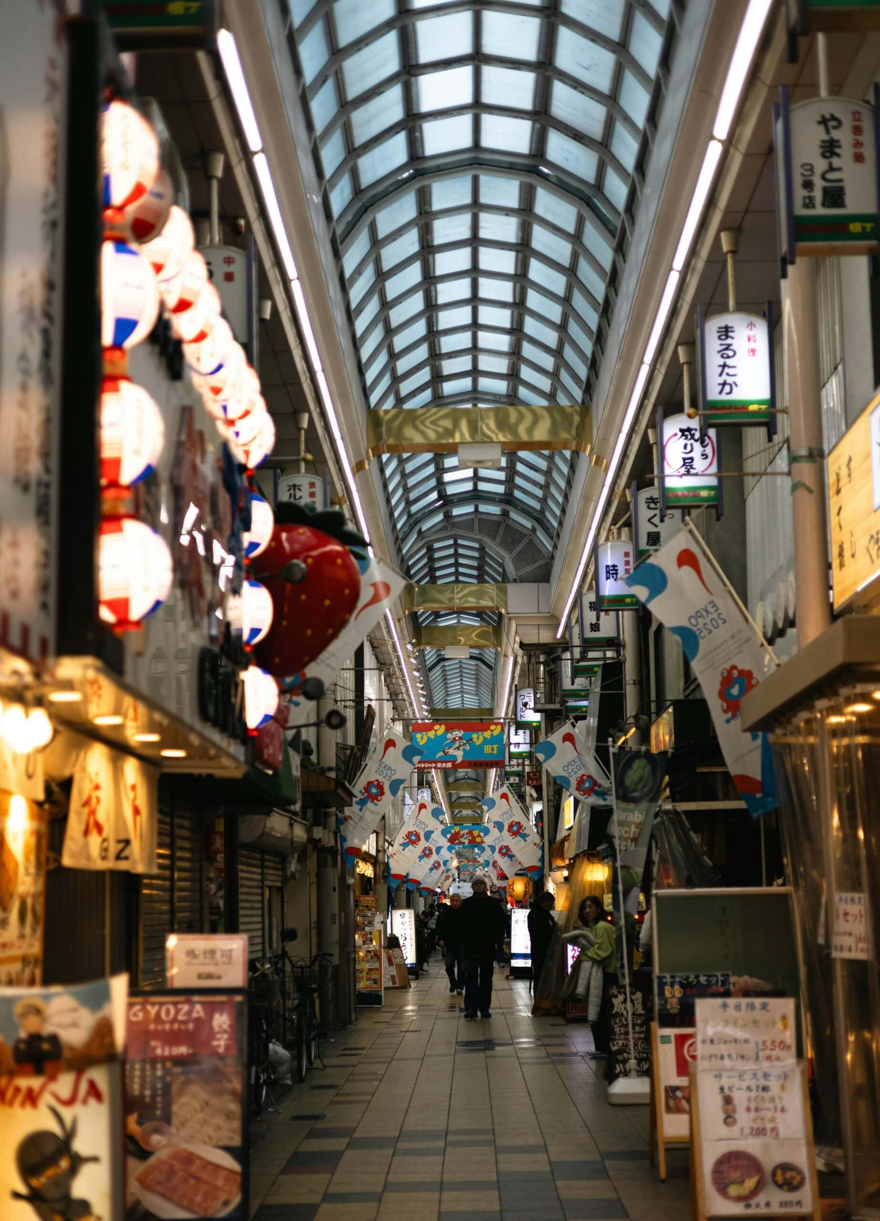 A long covered Japanese shopping arcade lined with lanterns and small shops, a natural shelter on day trips from Tokyo in the rain