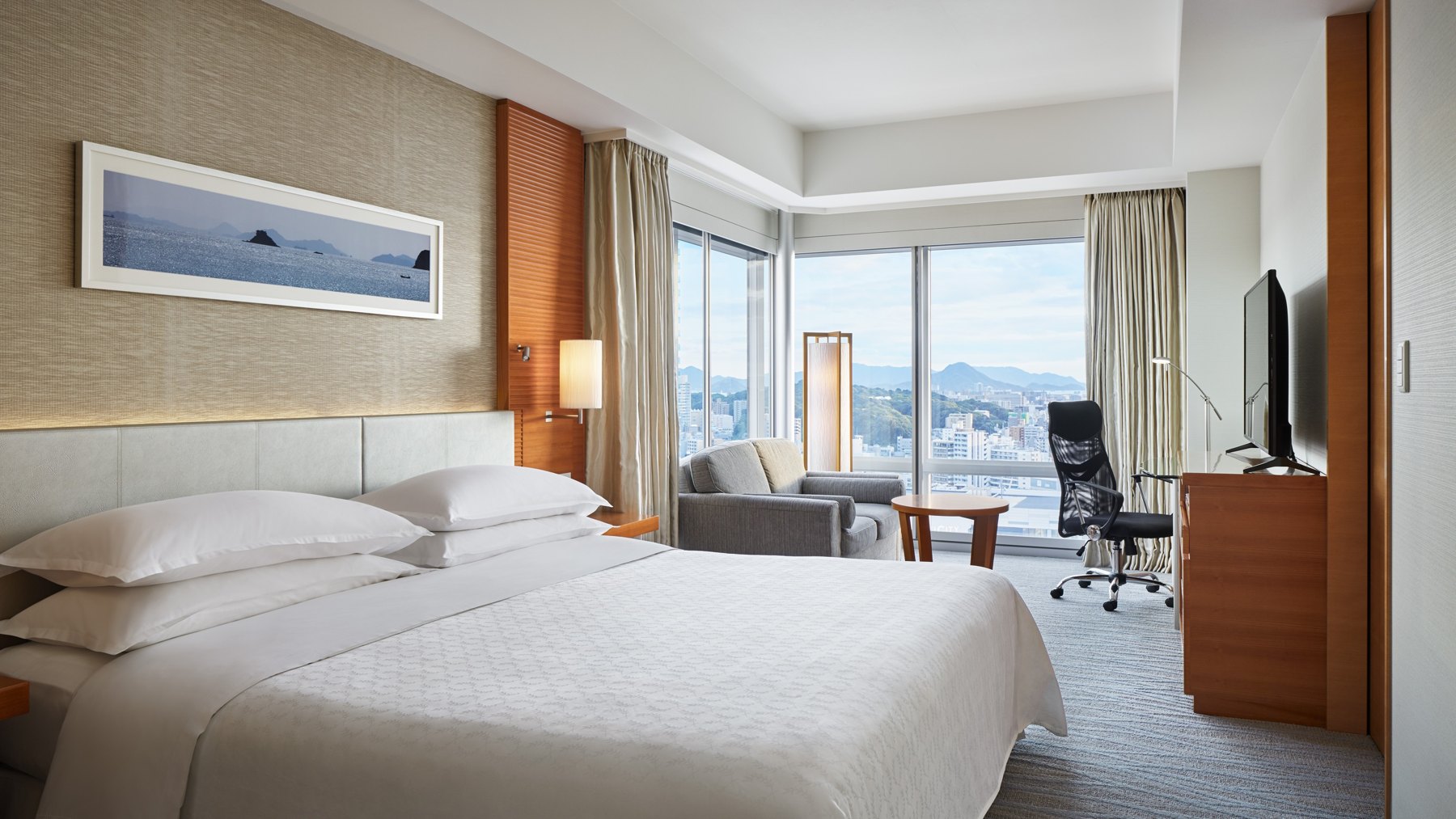 A king deluxe corner guest room at Sheraton Grand Hiroshima Hotel with city views