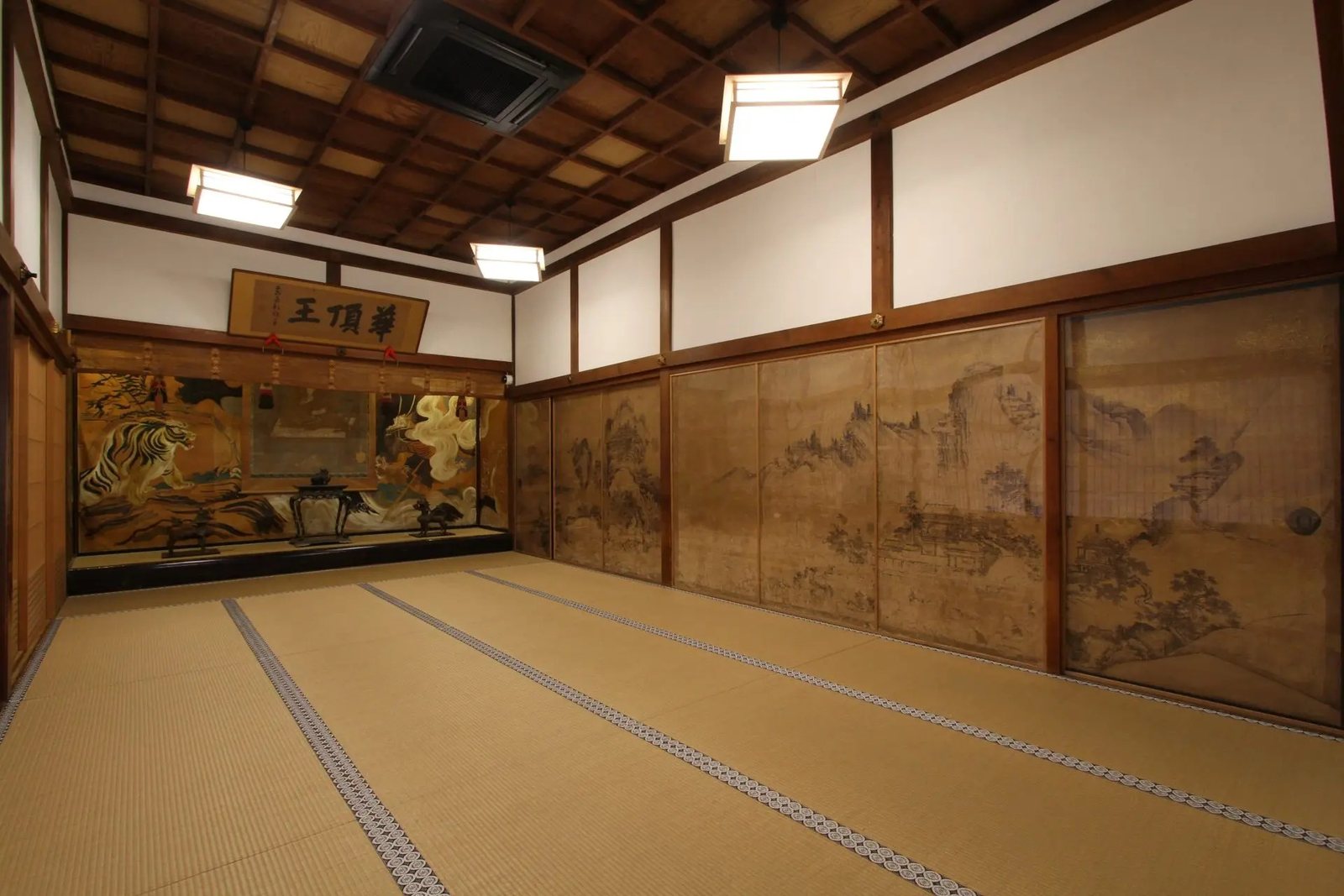 A large tatami room with painted sliding doors at Fukuchiin temple on Koyasan
