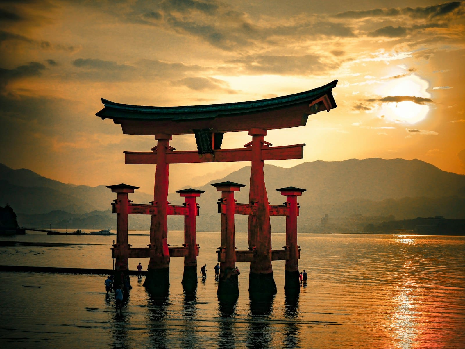The great torii gate of Itsukushima standing in the sea at sunset on Miyajima